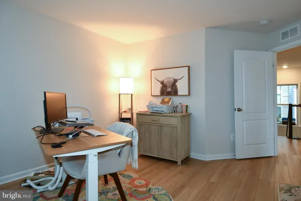 a view of a workspace with furniture and wooden floor