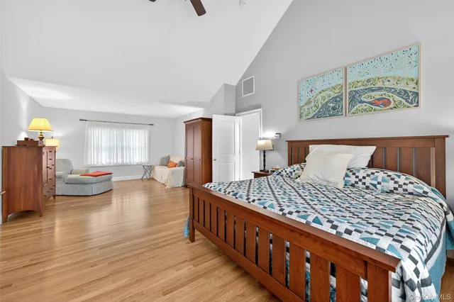 a bedroom with bed and wooden floor