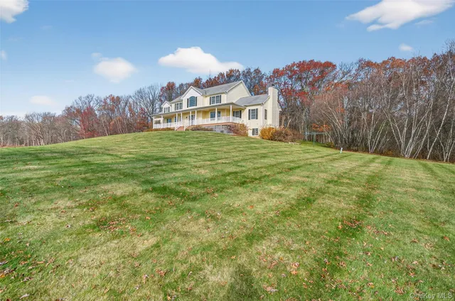 a view of a house with a big yard and large trees