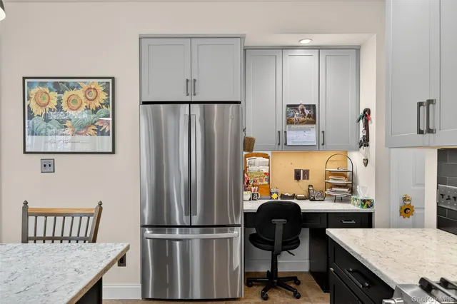 a view of a workspace with furniture and a window