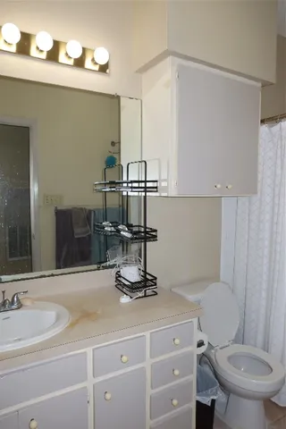 a bathroom with a toilet a sink and mirror