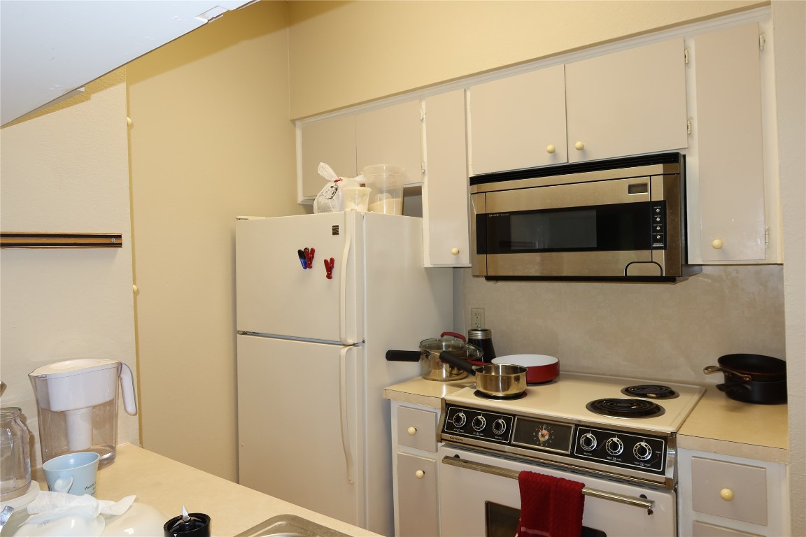 612 Park Place, Unit 202 Austin, TX 78705 - Photo 7 of 25 a kitchen with stainless steel appliances a refrigerator a stove a microwave and cabinets