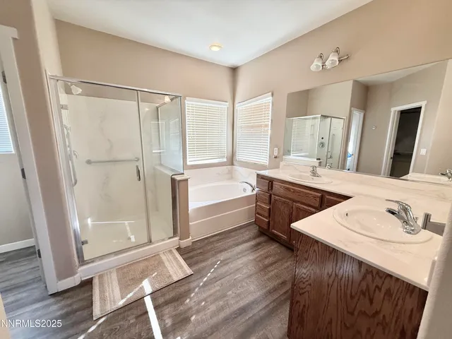 a spacious bathroom with a double vanity sink a mirror and a bathtub