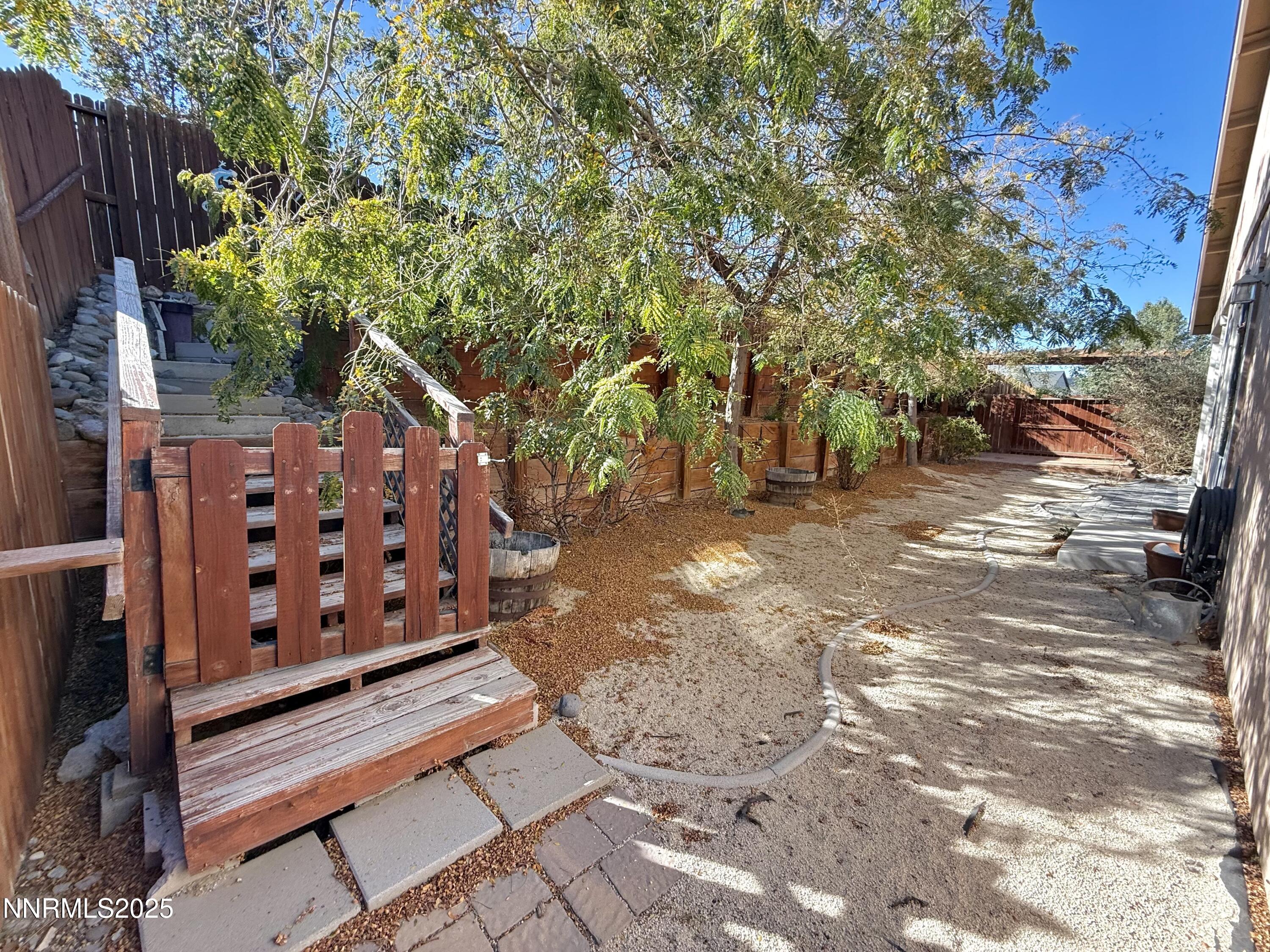 955 Aster Lane Fernley, NV 89408 - Photo 14 of 14 a view of a backyard with wooden fence and trees