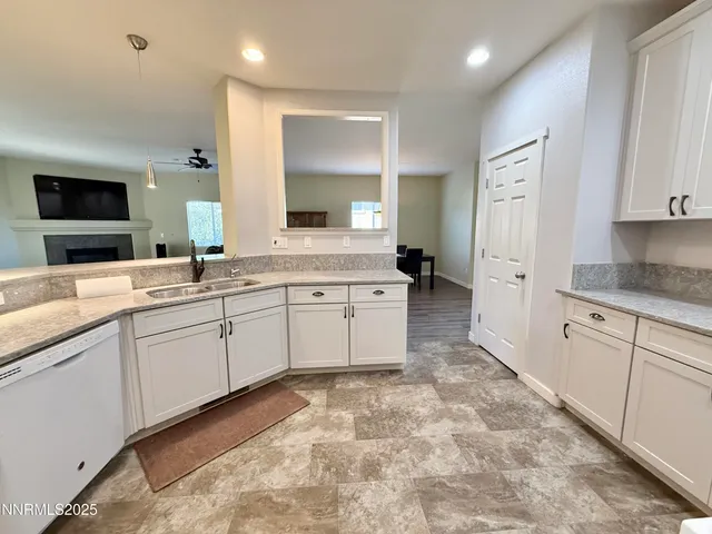 a large white kitchen with a sink and cabinets