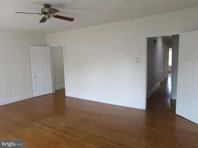 a view of an empty room with wooden floor