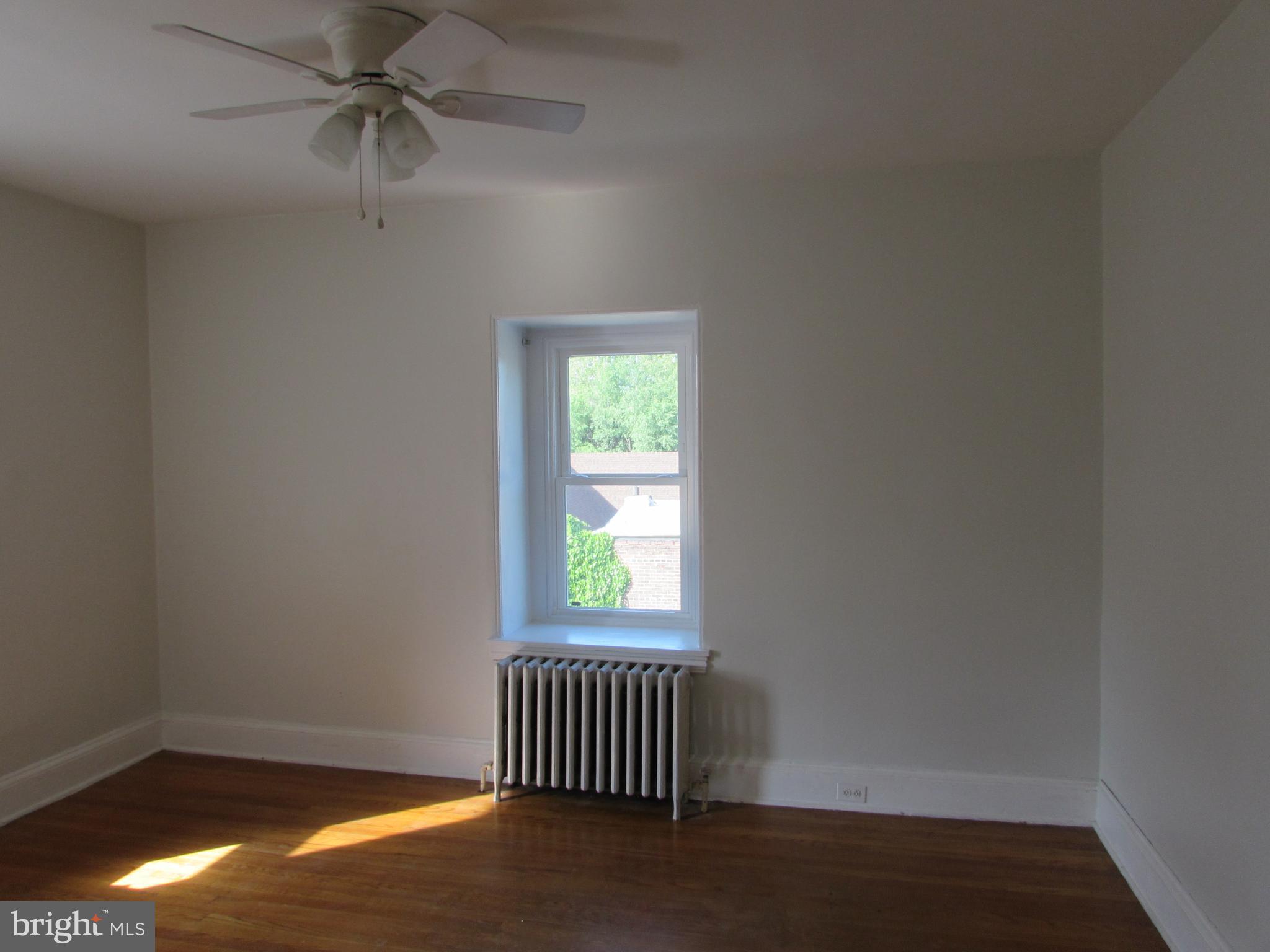 5903 Greene Street, Unit 3 Philadelphia, PA 19144 - Photo 13 of 19 an empty room with wooden floor fan and windows