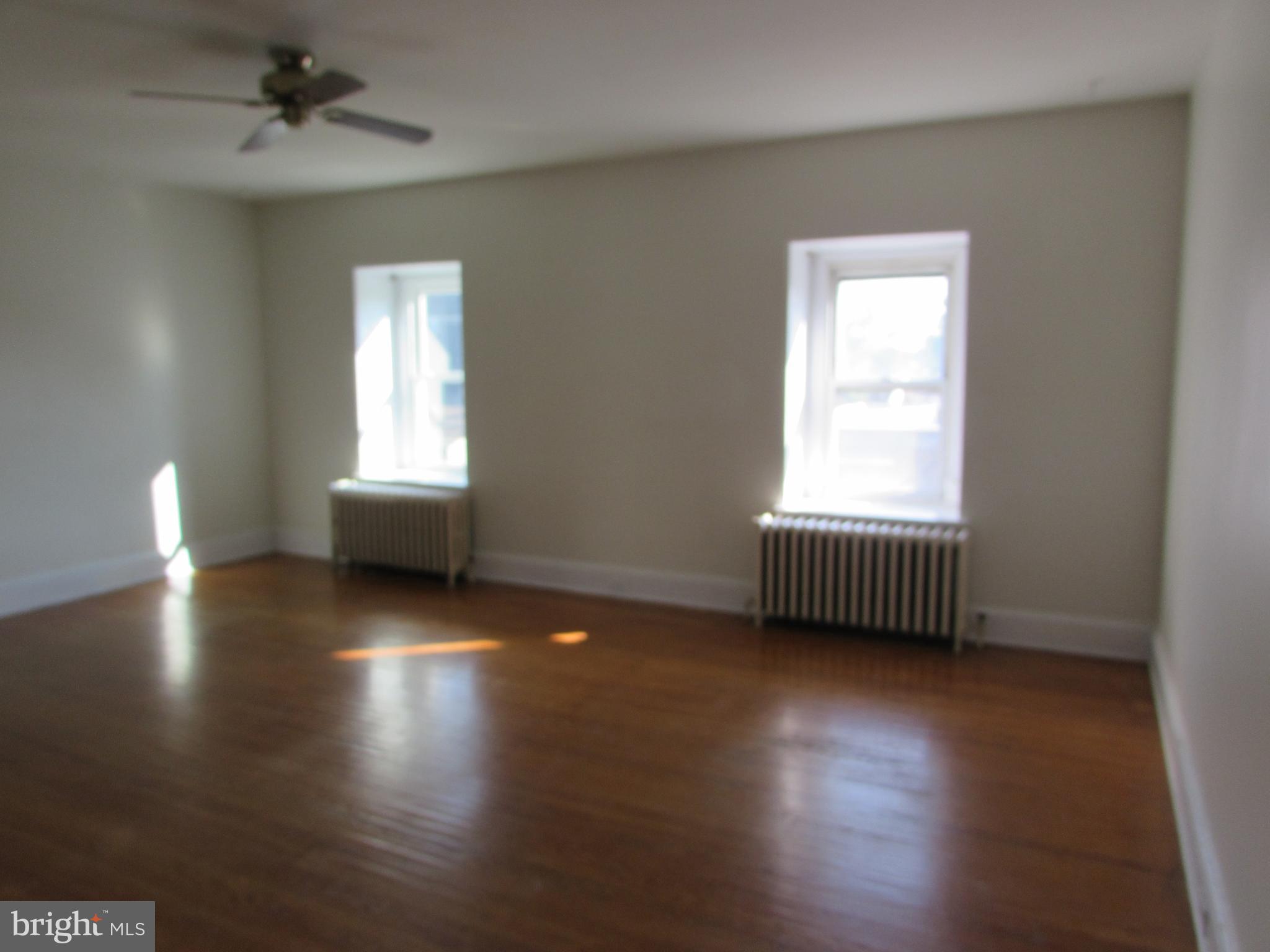 5903 Greene Street, Unit 3 Philadelphia, PA 19144 - Photo 9 of 19 an empty room with wooden floor and windows