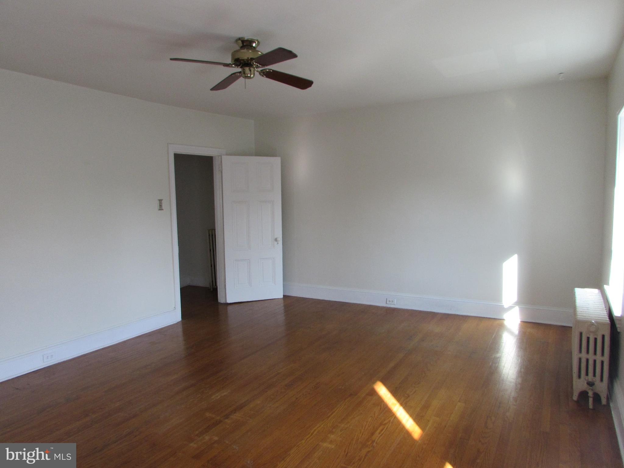 5903 Greene Street, Unit 3 Philadelphia, PA 19144 - Photo 10 of 19 a view of an empty room with a window and wooden floor
