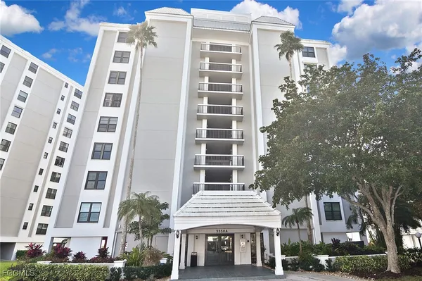 a front view of a multi story building with a yard