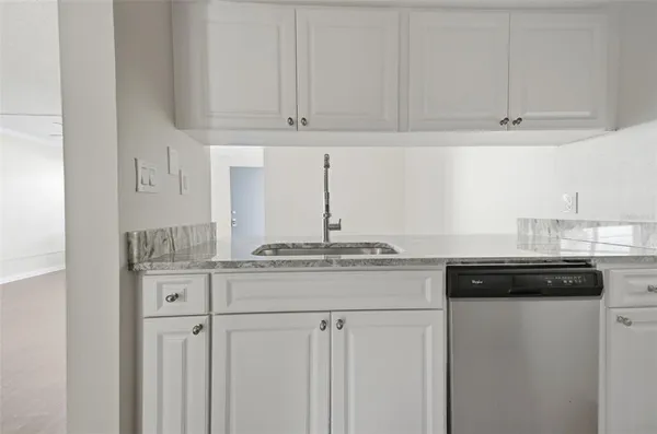 a kitchen with stainless steel appliances granite countertop white cabinets and a granite counter tops