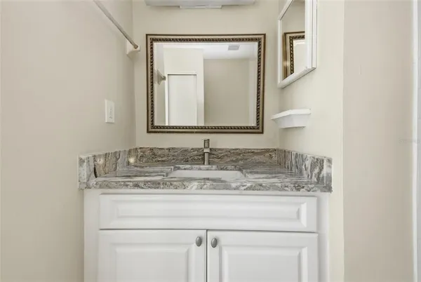 a bathroom with a granite countertop sink and a mirror