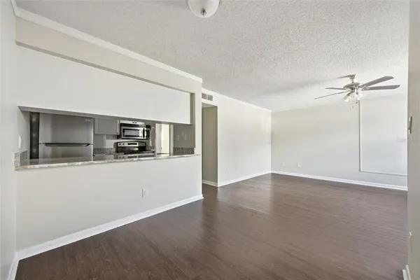 a view of kitchen with stainless steel appliances wooden floor and chair
