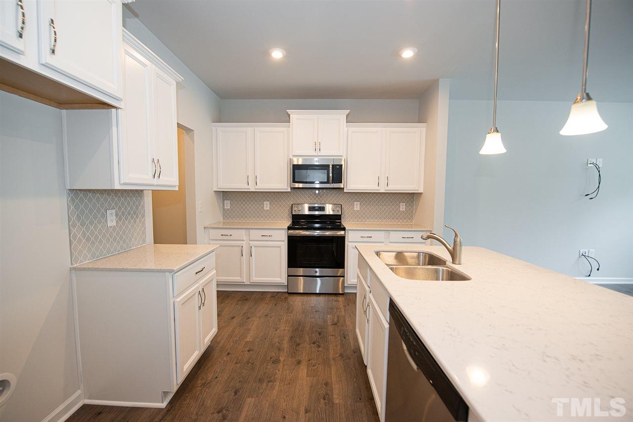 3610 Water Mist Lane, Unit 30 Raleigh, NC 27604 - Photo 8 of 25 a kitchen with a stove a sink and a refrigerator