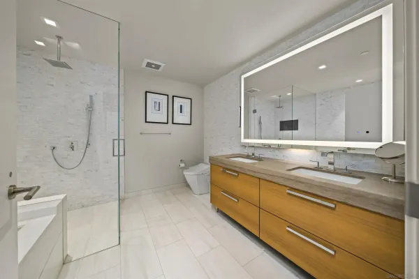 a spacious bathroom with a double vanity sink mirror and shower