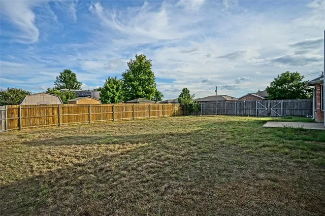 a view of a yard with wooden fence