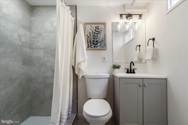 a bathroom with a toilet a sink and mirror