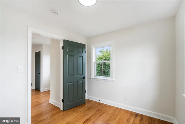 an empty room with wooden floor and a window
