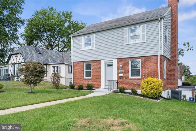 a front view of a house with a yard and green space
