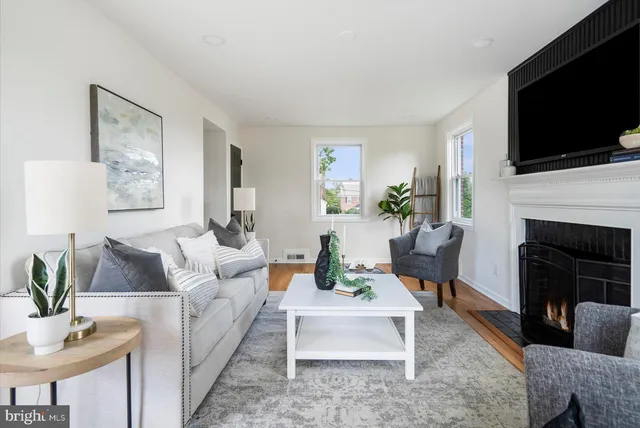 a living room with furniture a flat screen tv and a fireplace