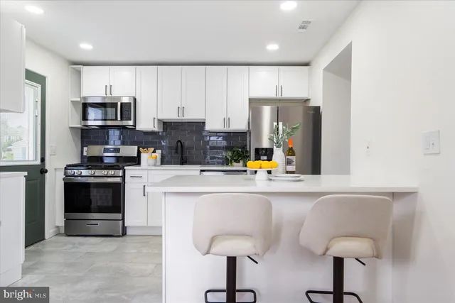 a kitchen with stainless steel appliances granite countertop a refrigerator and a stove top oven
