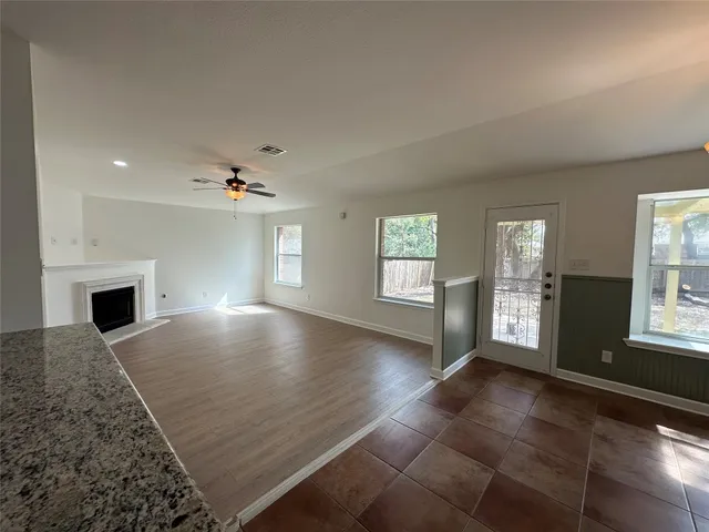 an empty room with windows and fireplace