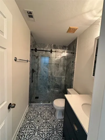a bathroom with a shower toilet and sink