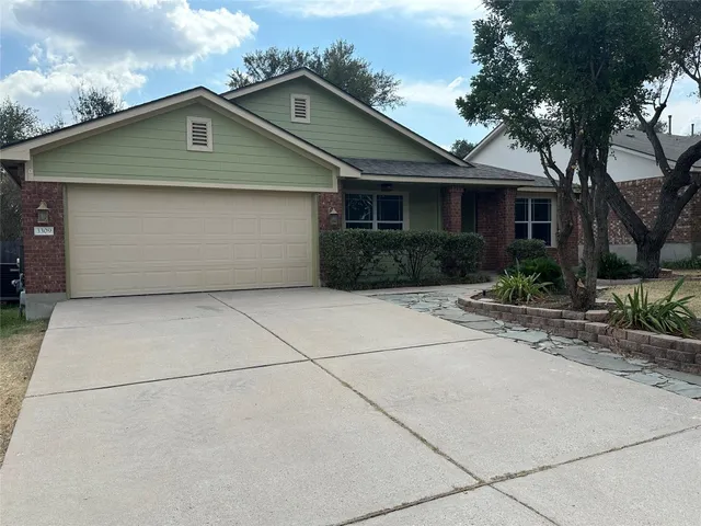 a front view of a house with a yard and potted plants