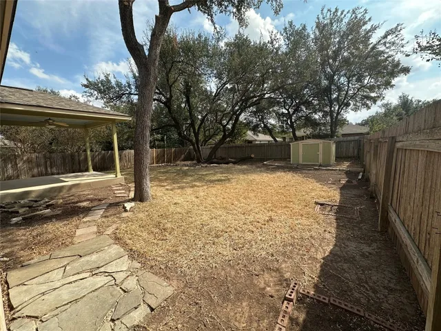 a backyard of a house with a small barn and wooden fence