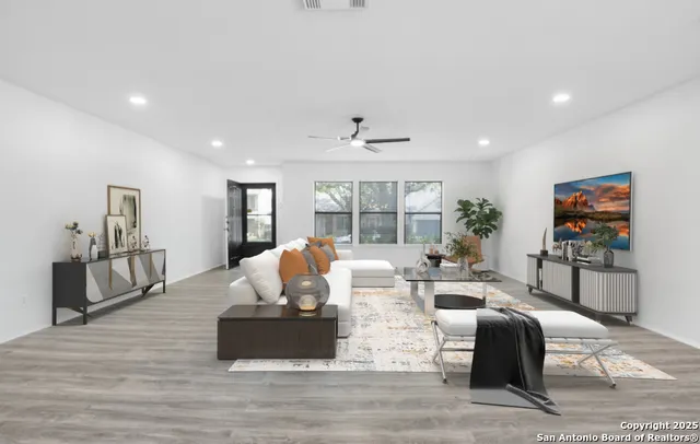 a living room with furniture large window and wooden floor