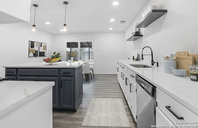 a kitchen with sink a refrigerator and cabinets
