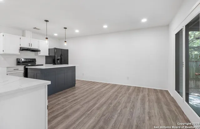 a view of kitchen with wooden floor electronic appliances and window