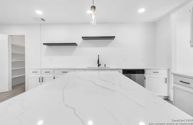 a view of a kitchen with white cabinets