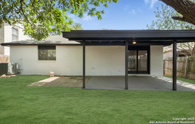 a backyard of a house with table and chairs