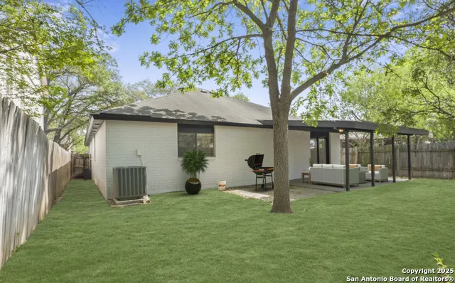 a backyard of a house with table and chairs
