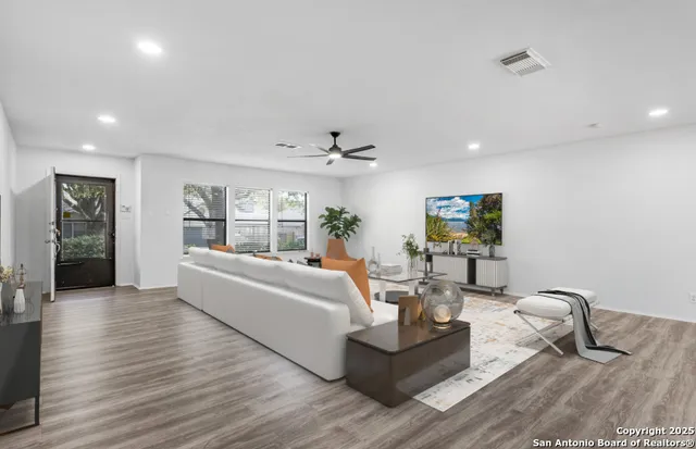 a living room with furniture and wooden floor