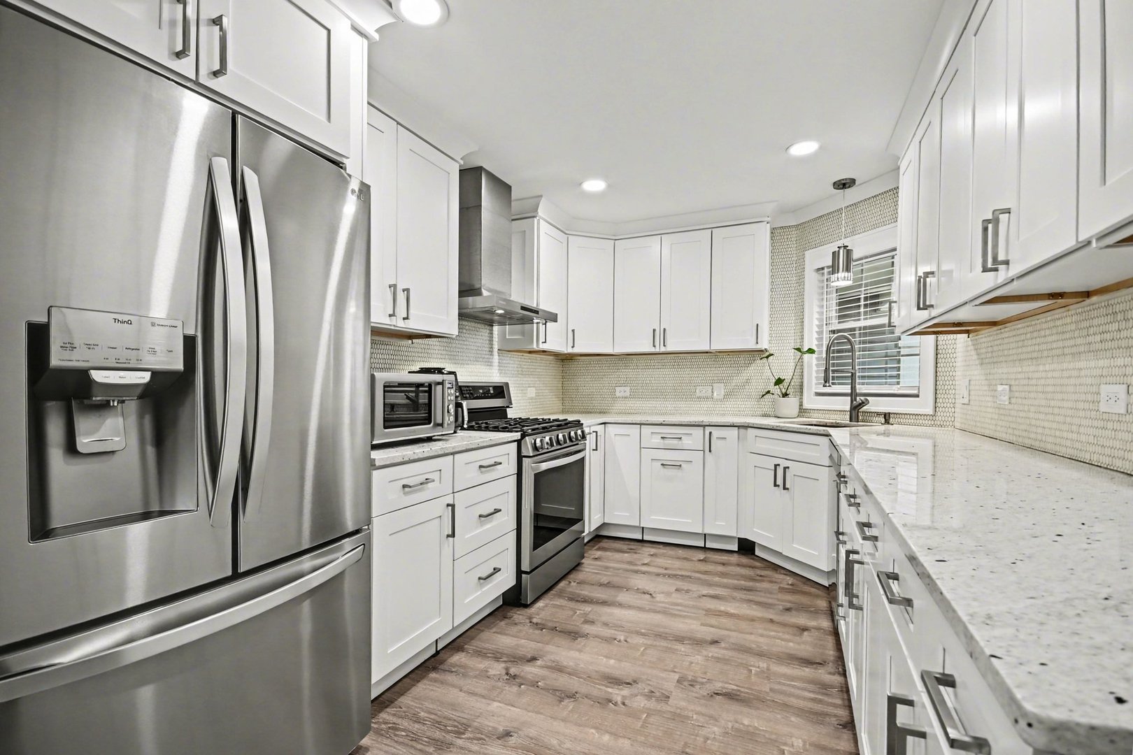 850 Spring Creek Court Elk Grove Village, IL 60007 - Photo 12 of 26 a kitchen with stainless steel appliances granite countertop a refrigerator a stove and white cabinets with wooden floor