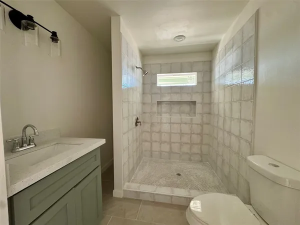 a bathroom with a shower a sink and toilet