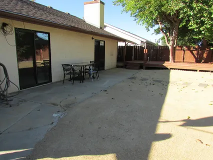 a backyard of a house with wooden floor and outdoor seating