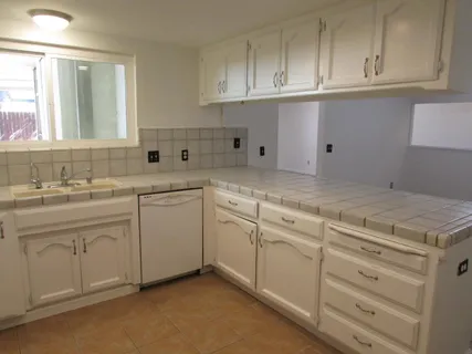 a kitchen with cabinets appliances a sink and a window