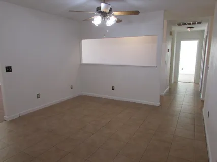 an empty room with wooden floor fireplace and windows
