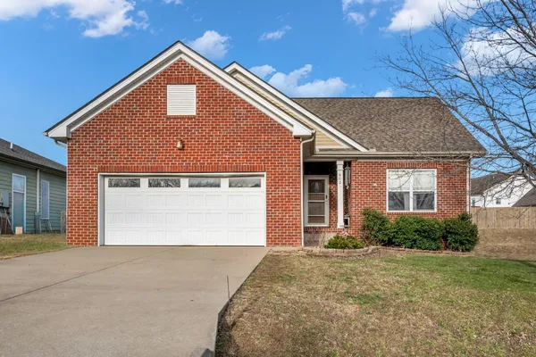 a front view of a house with a garden and plants