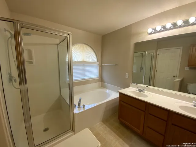 a bathroom with a tub sink shower and mirror