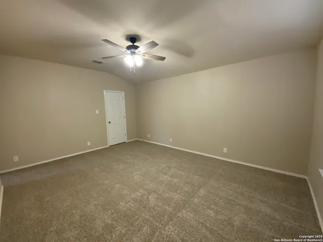 an empty room with a fan and a fan
