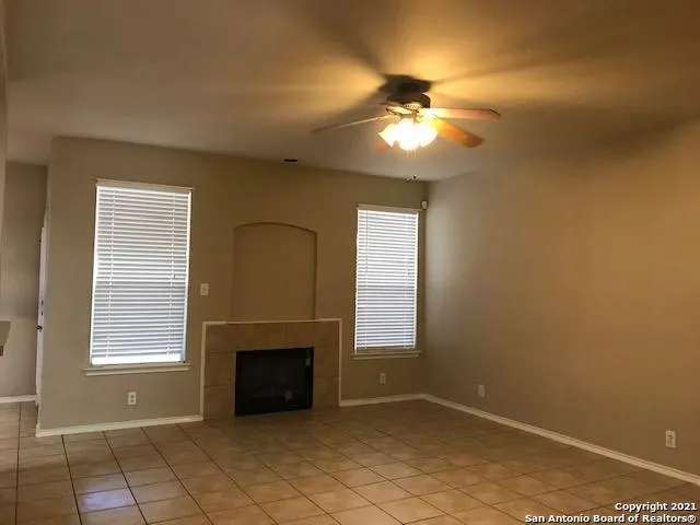 an empty room with windows and fireplace