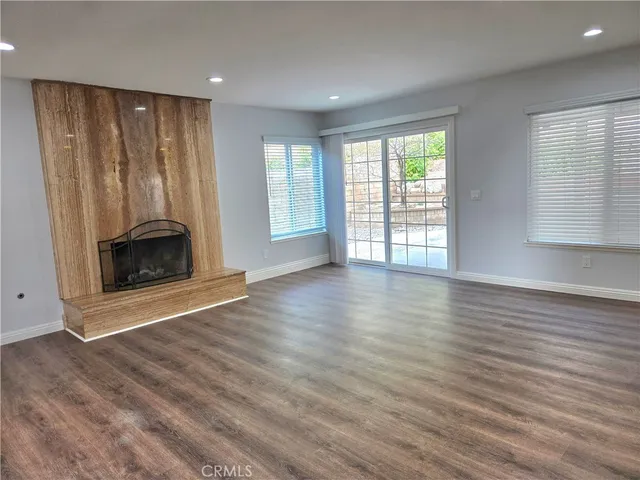 an empty room with wooden floor and fireplace