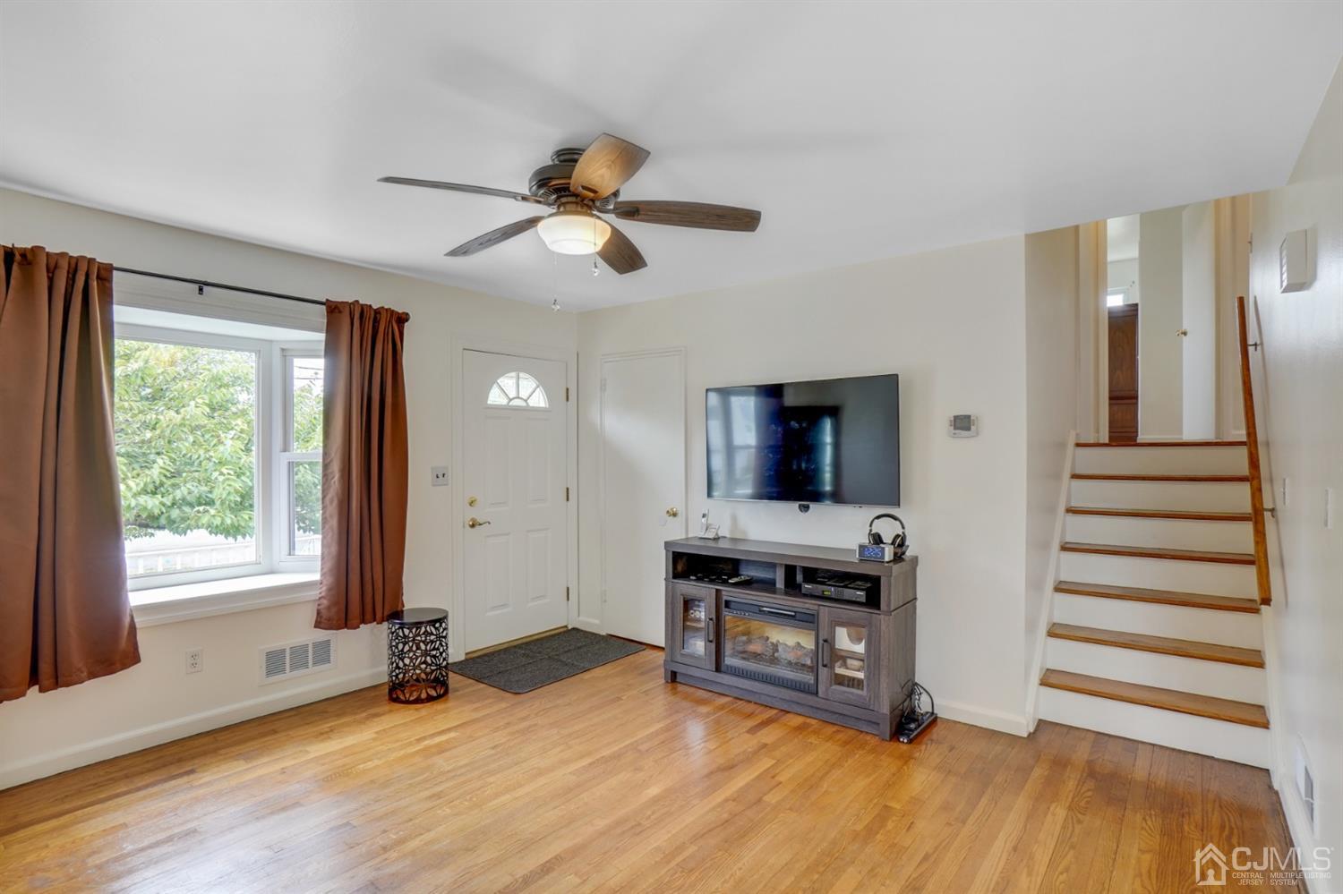 12 Leland Road Edison, NJ 08817 - Photo 8 of 23 a view of a livingroom with wooden floor and a ceiling fan