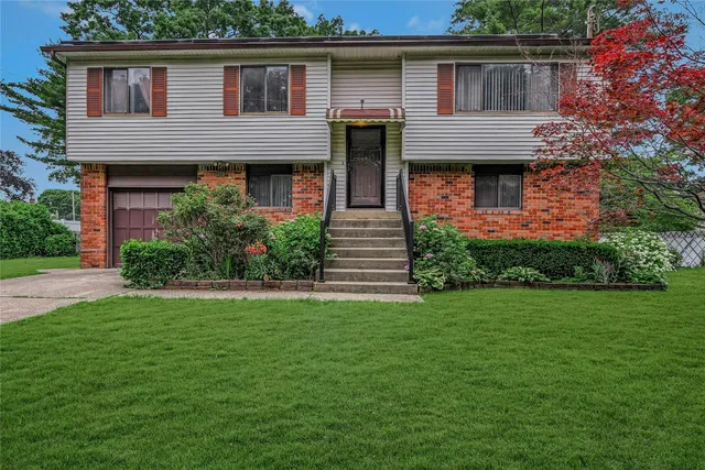 a front view of a house with a garden and plants