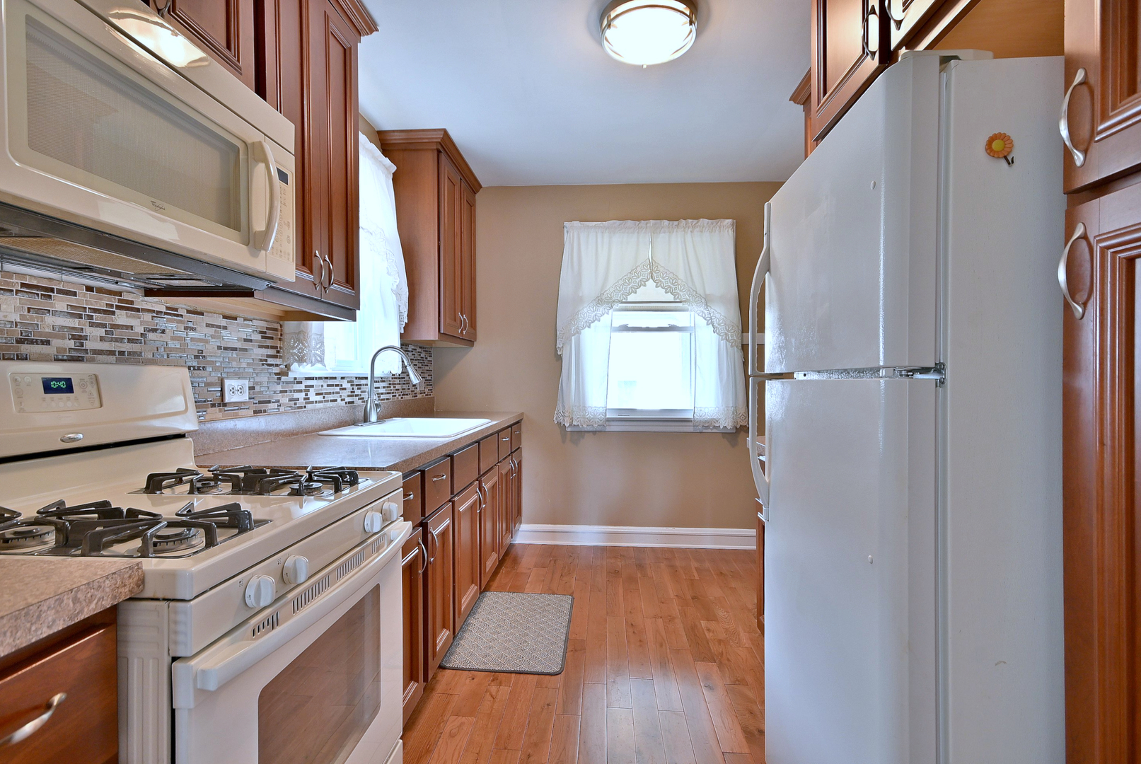 2852 North Meade Avenue Chicago, IL 60634 - Photo 9 of 31 a kitchen with a stove a sink and a refrigerator