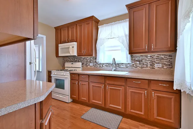 a kitchen with granite countertop a sink dishwasher stove and cabinets